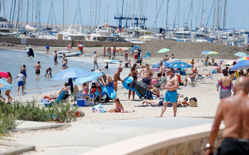 FILE PHOTO: People sunbathe on Playa de Palma beach in