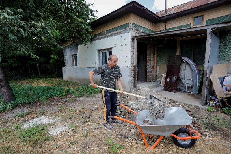 Alberto Gogu uses a shovel to clear debris in his