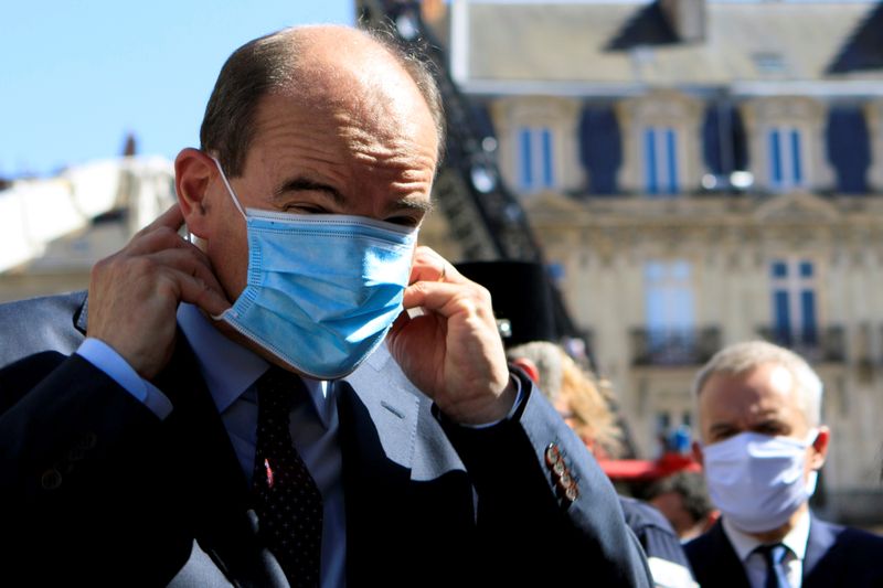 FILE PHOTO: French Prime Minister Jean Castex adjusts his protective