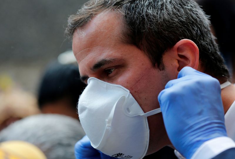 Venezuelan opposition leader Juan Guaido takes off his protective mask