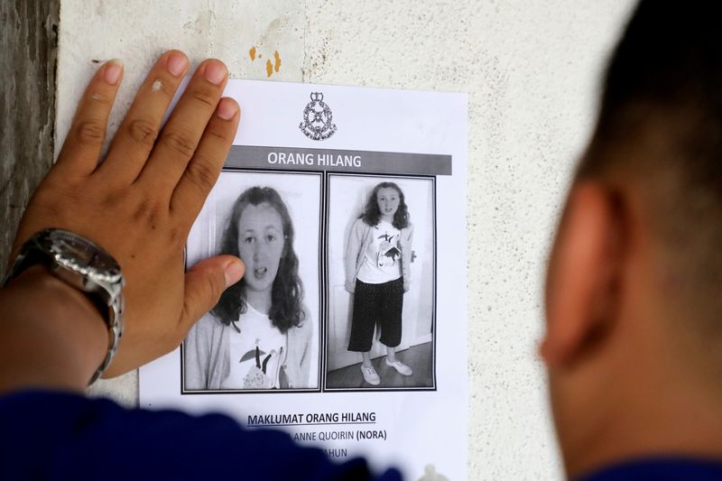 FILE PHOTO: A police officer paste a photo of 15-year-old