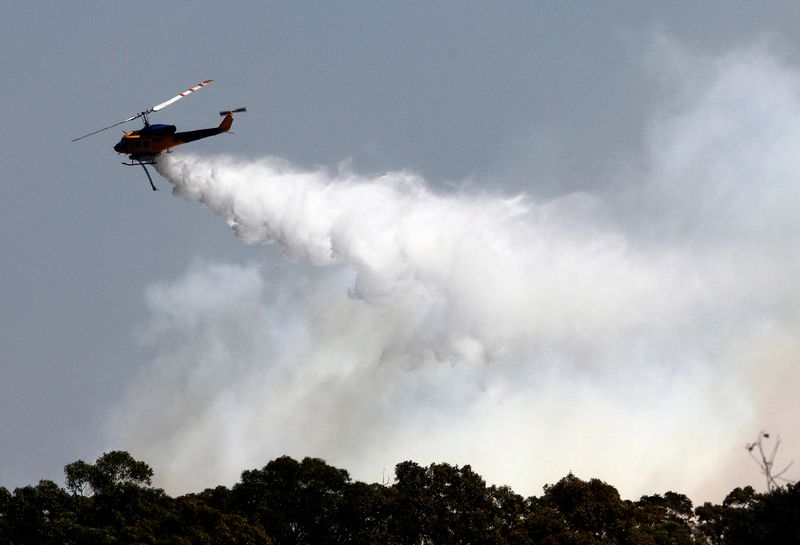 A helicopter drops water in an attempt to extinguish a