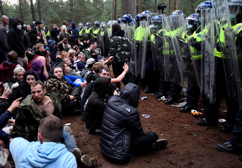 Revellers sit after a police shut down a suspected illegal