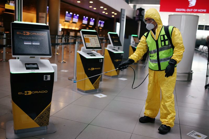 A man wearing protective gear disinfects a facility of the