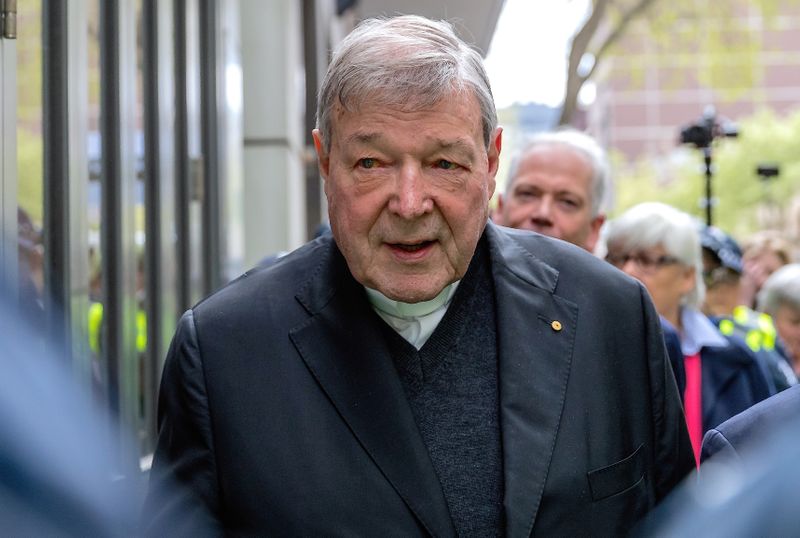 FILE PHOTO – Vatican Treasurer Cardinal George Pell is surrounded