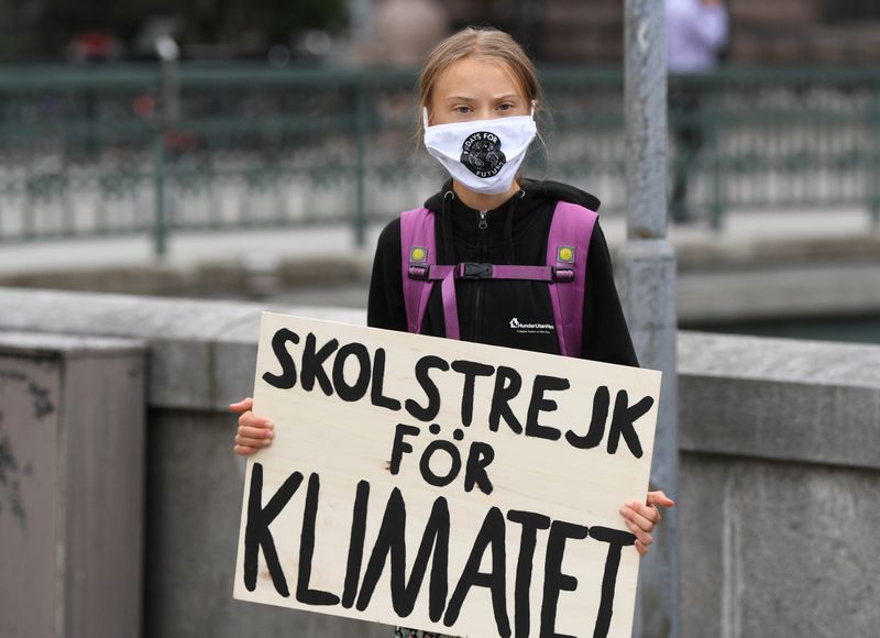 Swedish climate activist Greta Thunberg holds a poster reading “School
