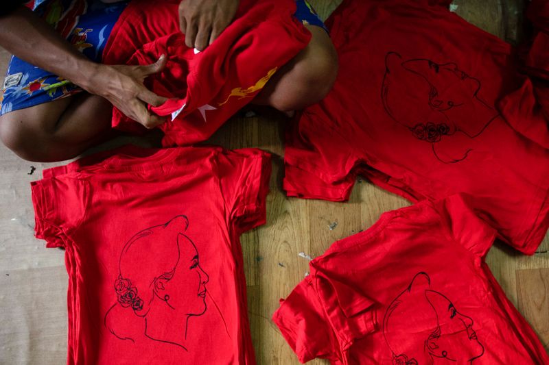 A worker prepares t-shirts depicting Aung San Suu Kyi at