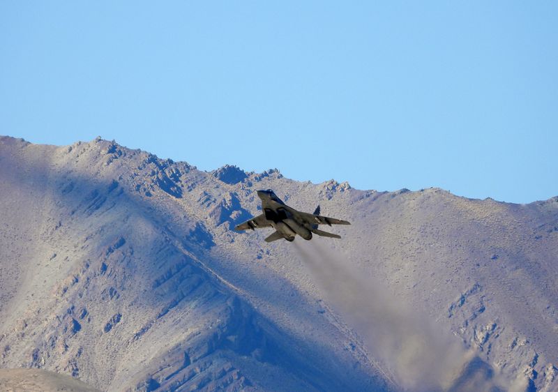 An Indian fighter plane flies over a mountain range in