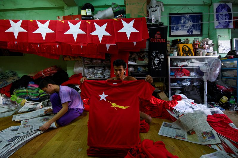 A worker prepares t-shirts with the logo of Aung San