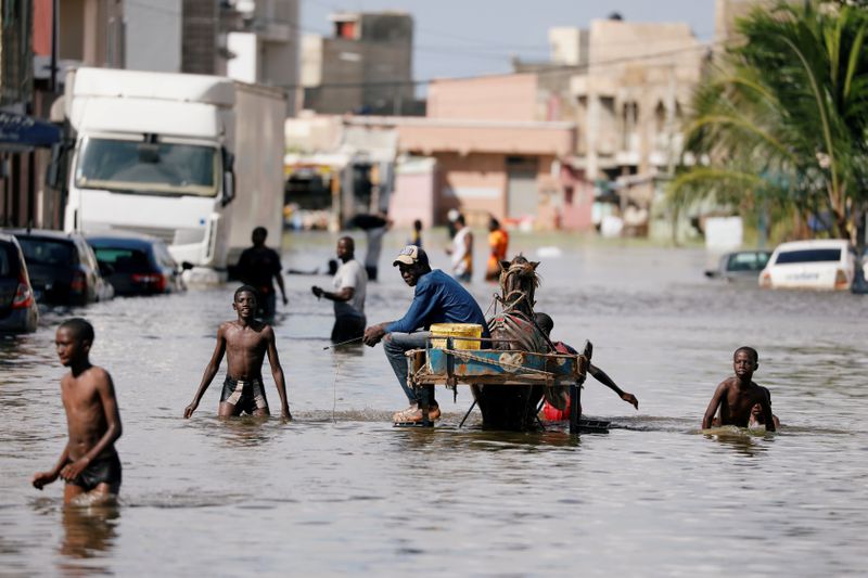 FILE PHOTO: Residents walk through a flooded street after last