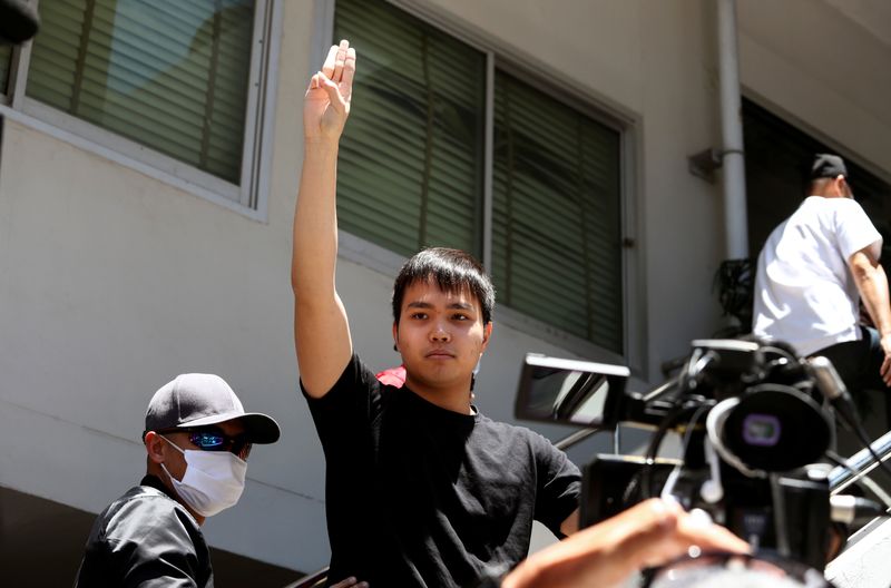 Pro-democracy leader Tattep Ruangprapaikitseree flashes the three-fingers salute as he