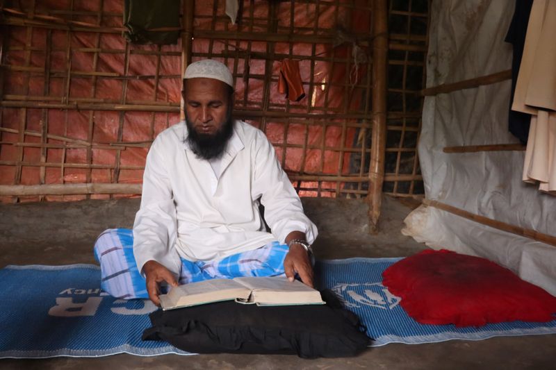 Mohammed Rofiq, a Rohingya refugee, reads Islamic scripture in his