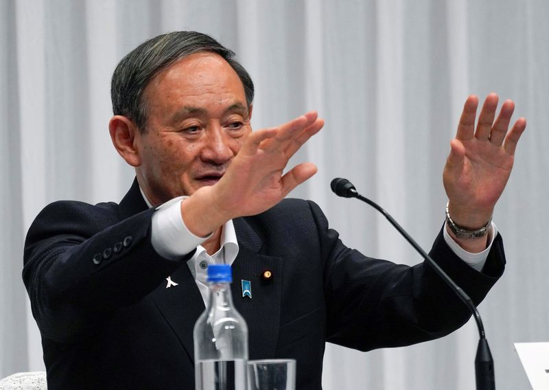 FILE PHOTO: Japan’s Chief Cabinet Secretary Yoshihide Suga waves after