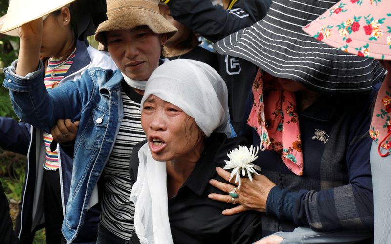 FILE PHOTO: Tran Thi Hien cries while following an ambulance