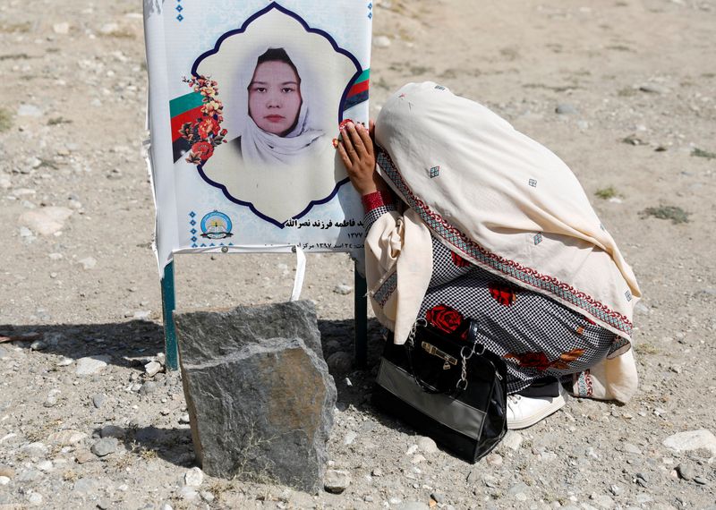 A woman mourns over the grave of her daughter who