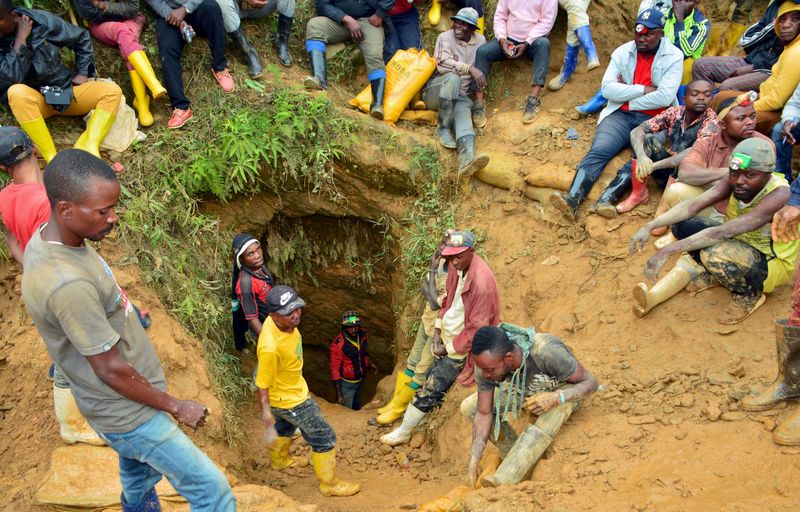 FILE PHOTO: Congolese artisanal gold miners sit outside a mine-pit