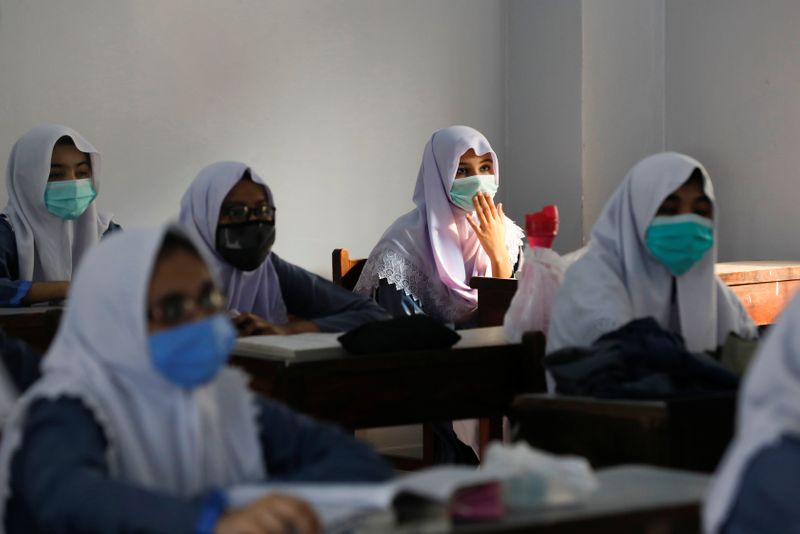 Students wear protective masks while maintaining safe distance as they