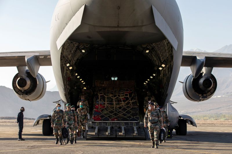 Indian soldiers disembark from a military transport plane at a