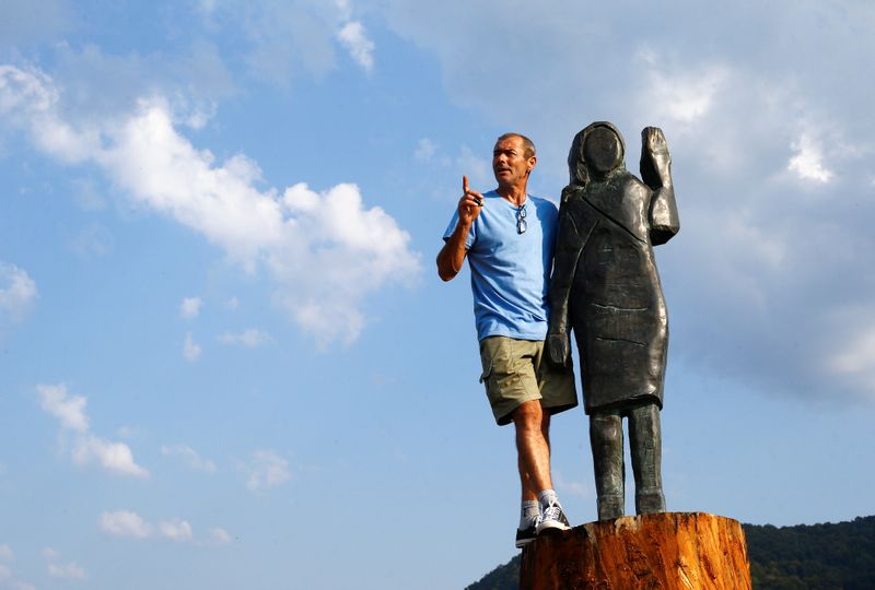Ales Zupevc poses next to the new bronze statue of