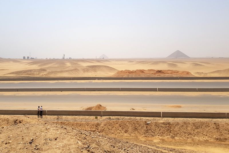 People walk as a new superhighway cuts across desert within