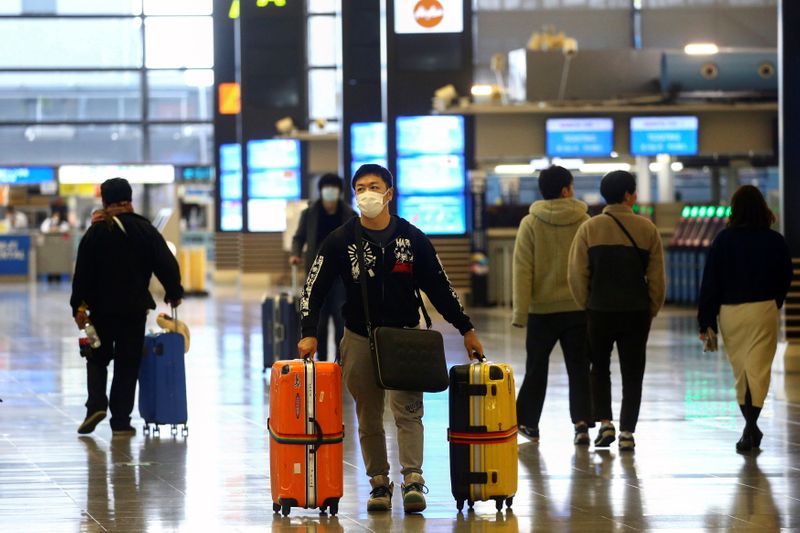 FILE PHOTO: A passenger, wearing protective mask following an outbreak