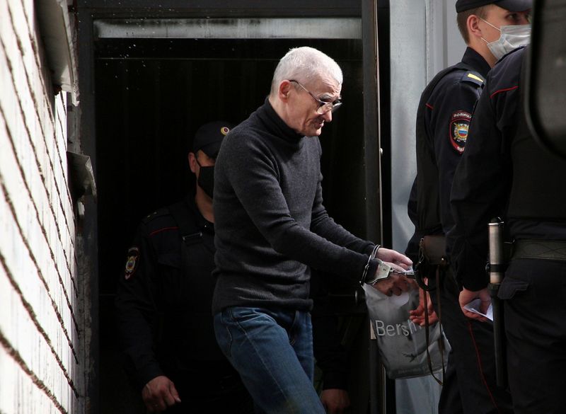 Russian historian Yuri Dmitriev is escorted by police officers after