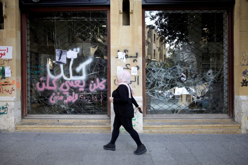 FILE PHOTO: A woman walks past a closed bank office
