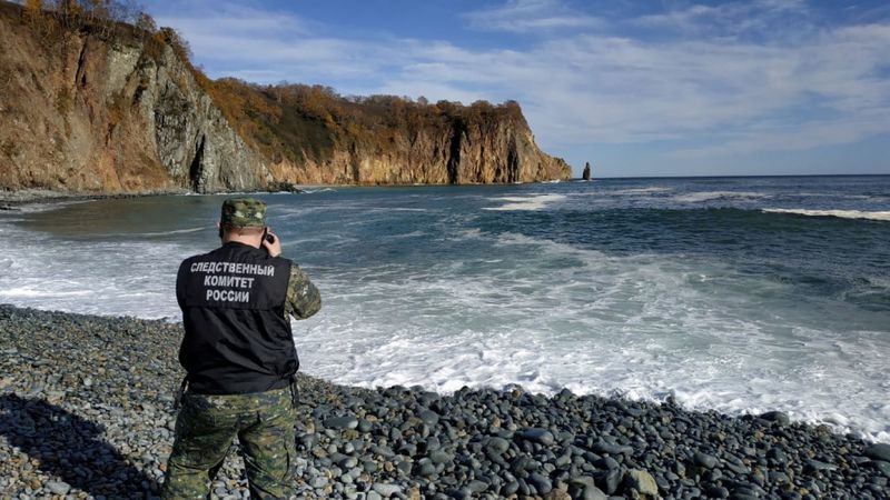 A member of Russian Investigative Committee works on the shore