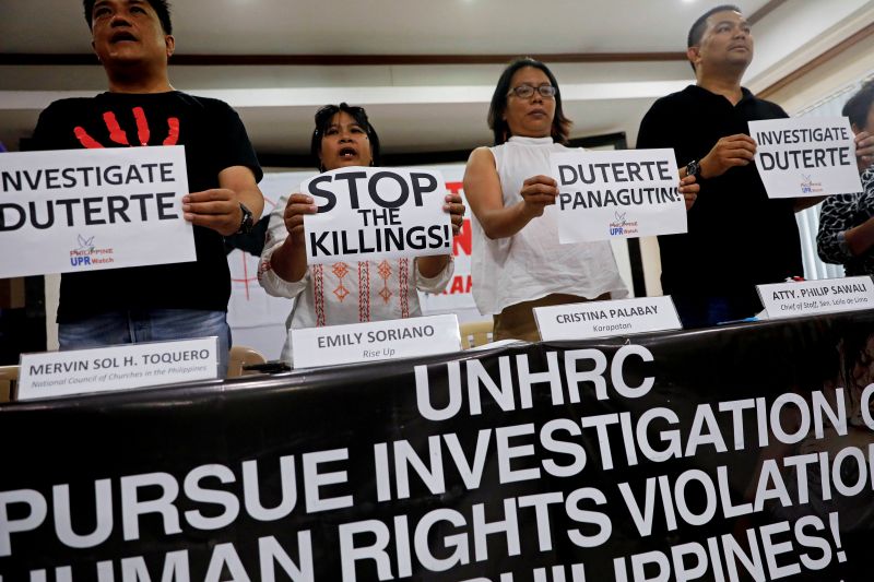 FILE PHOTO: Members of the human rights groups hold banners