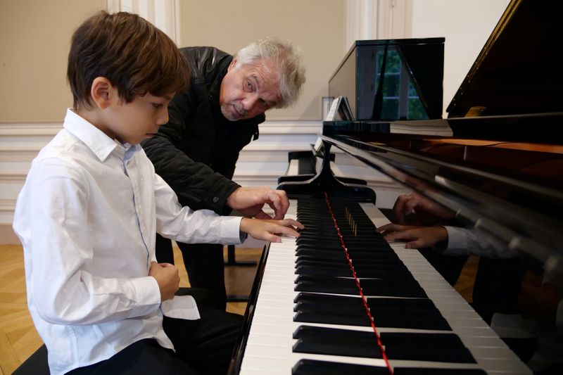 Guillaume Benoliel, a six-year-old child, practices the piano with his