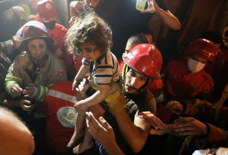 Rescuers carry a child that was evacuated from a building
