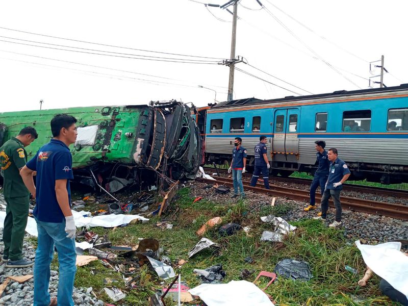Rescue workers stand at the crash site where a train