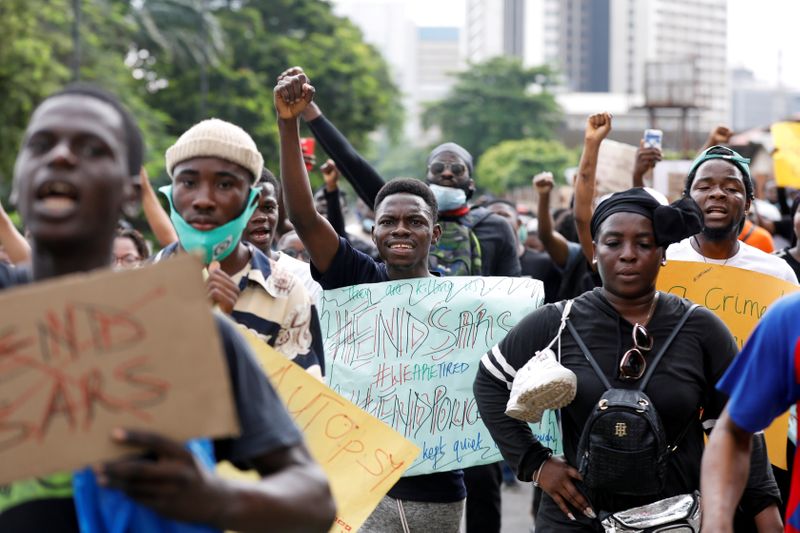 Nigerians take part in a protest against alleged violence, extortion