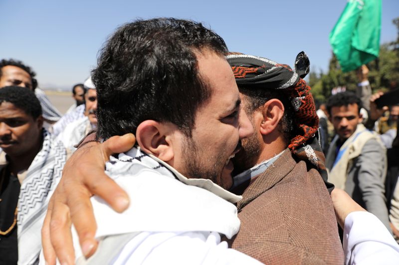 A Houthi fighter hugs a relative upon his arrival at