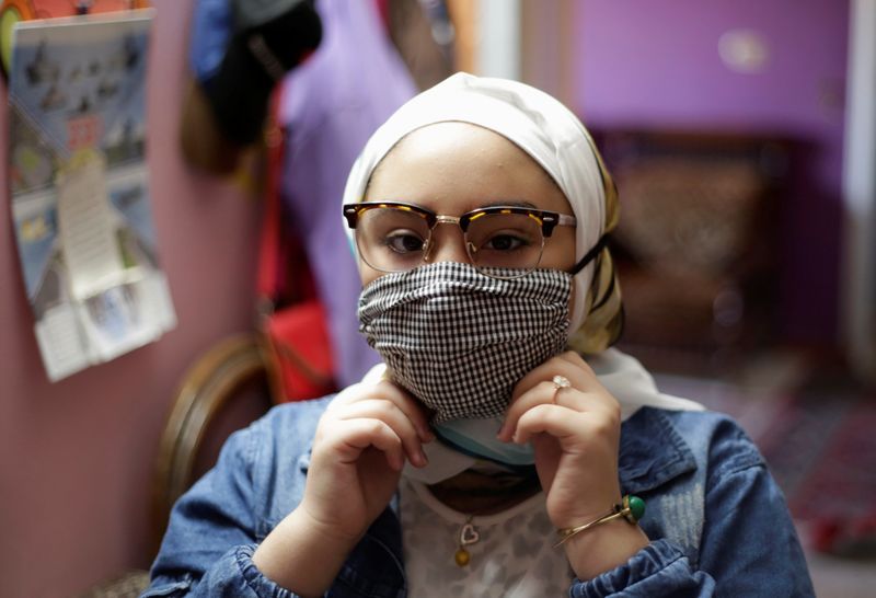Sama Mohamed, 12, wears a protective face mask amid the