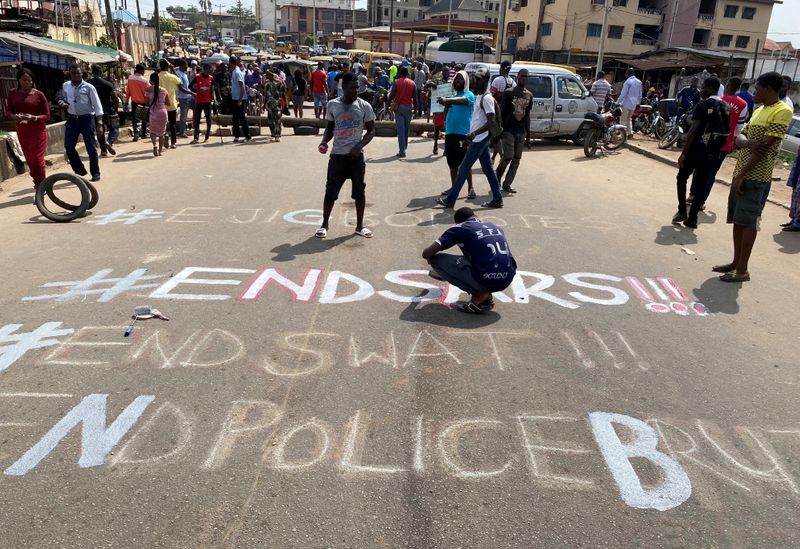 A demonstrator paints ‘End Sars’ during a protest demanding police