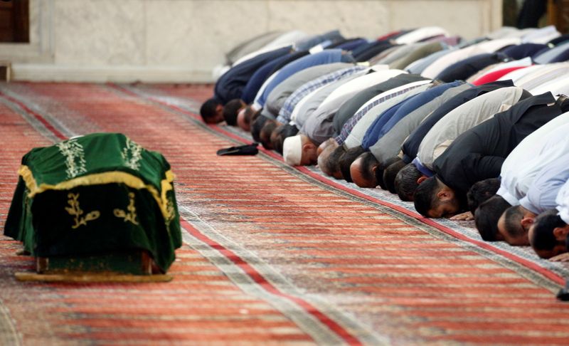 Mourners pray near the coffin of Sunni Muslim Mufti Sheikh