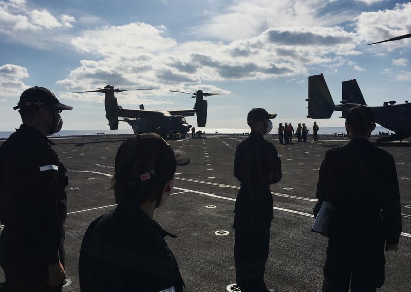 Japan Maritime Self-Defense Force soldiers watch U.S. MV-22 Osprey aircrafts