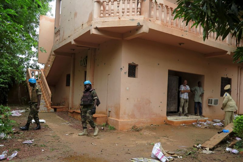 FILE PHOTO: Malian soldiers survey the damage after a hotel