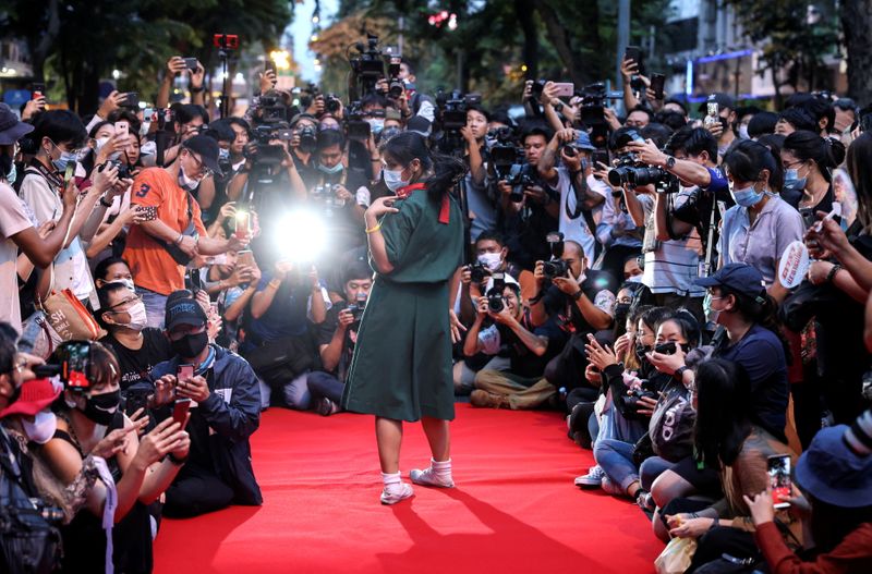A protester performs on a red carpet while taking part
