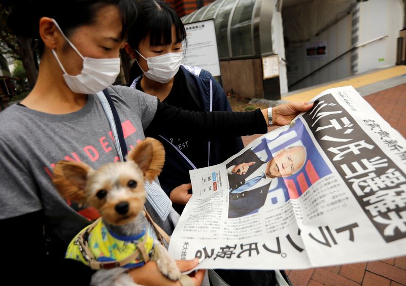 FILE PHOTO: People in Tokyo read an extra edition of