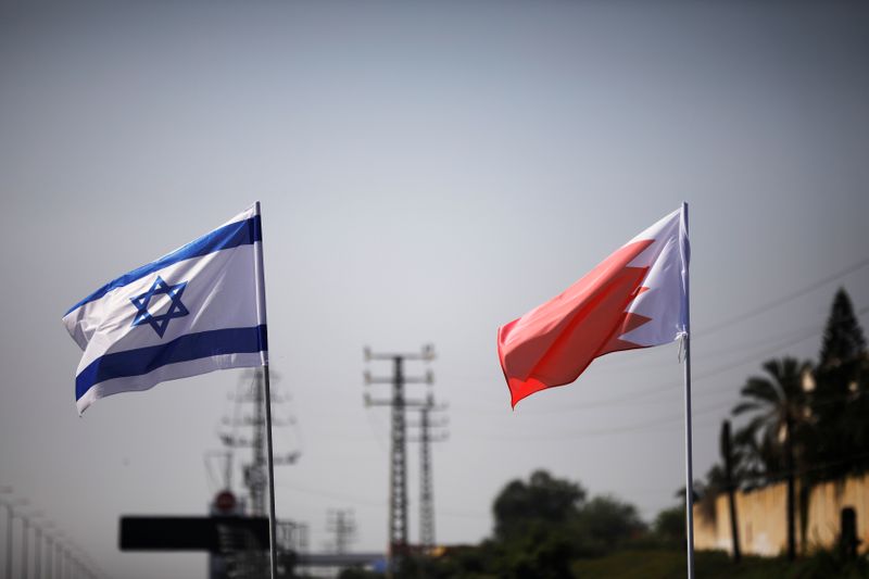 The flags of Israel and Bahrain flutter along a road