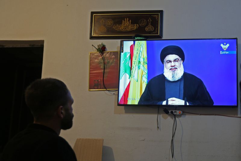 FILE PHOTO:  A man watches Lebanon’s Hezbollah leader Sayyed