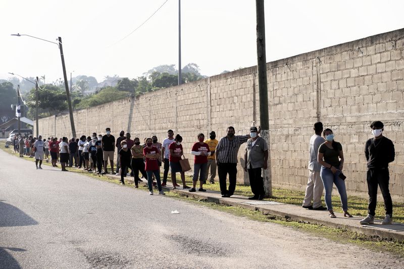People queue outside a polling station to cast their vote