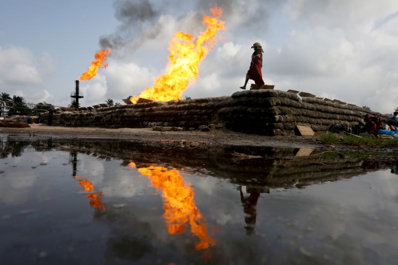 FILE PHOTO: A reflection of two gas flaring furnaces and