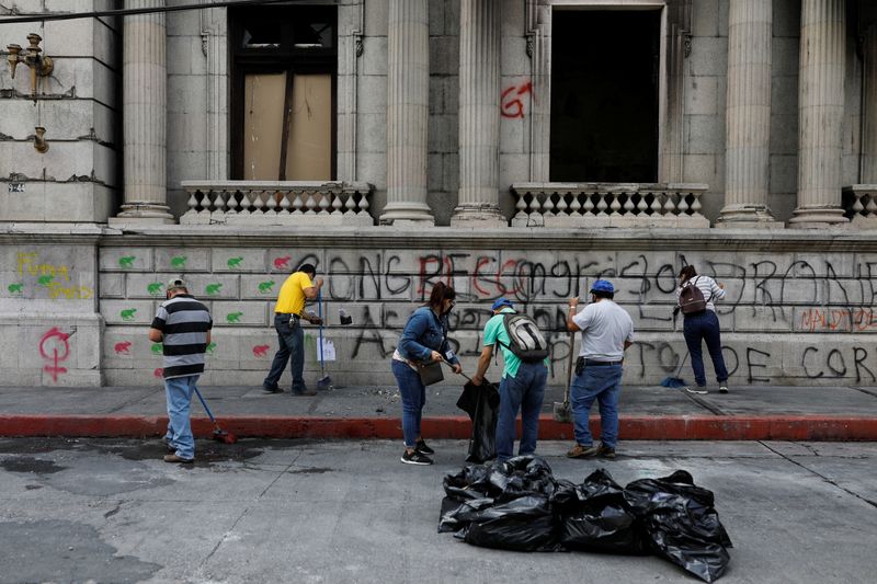 Workers clean the outside of the Congress building, a day