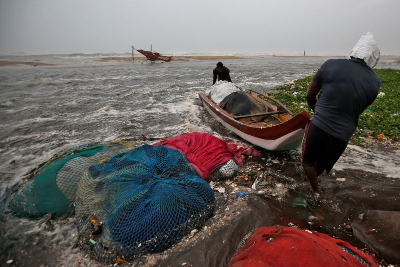 Fishermen move a fishing boat to a safer place along