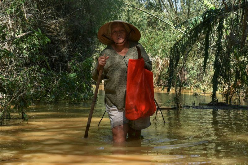 FILE PHOTO: A woman walks in a flooded road after