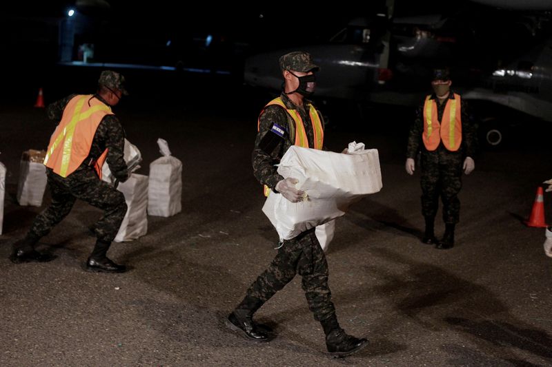 FILE PHOTO: Soldiers carry cocaine packages seized during an operation