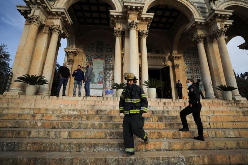 Israeli police and firefighters stand outside the Church of All